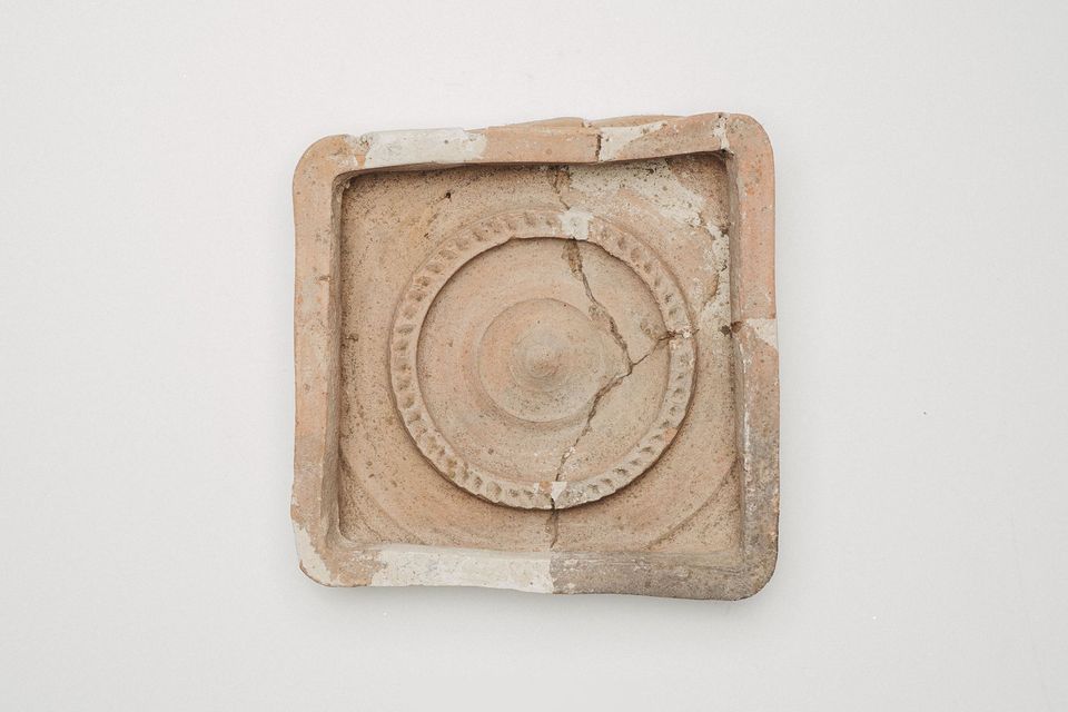 Cahlă de sobă pătrată cu un medalion circular în relief, văzută de sus