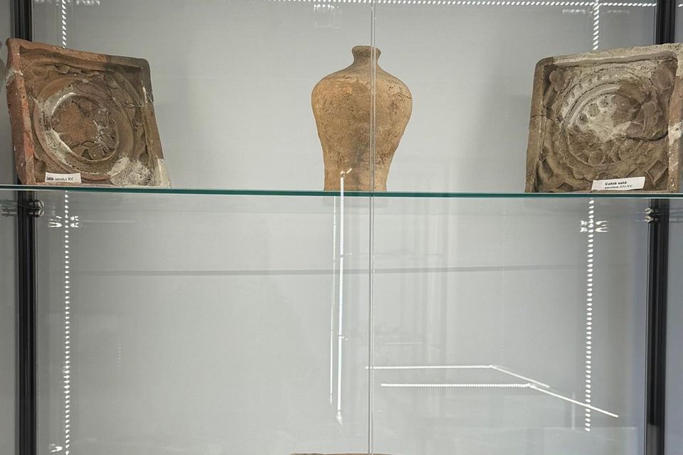 Cahle cu decor în relief și fragmente ceramice pe rafturi de sticlă