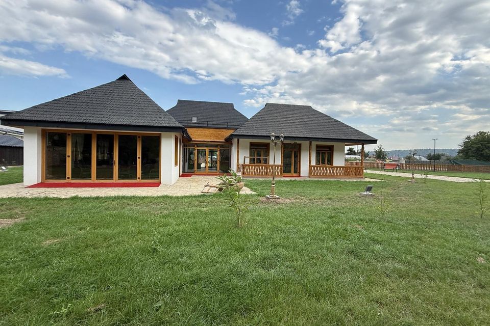 Colț de atelier cu vase din doage, unelte și covor înflorat pe perete