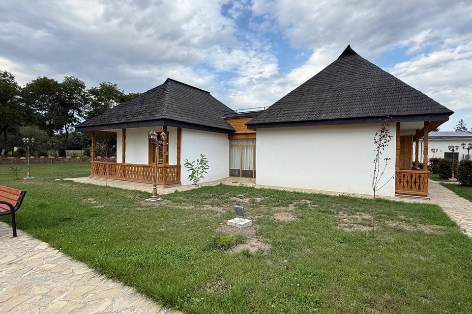 Colțul clădirii muzeului, cu peluza și aleea din curte