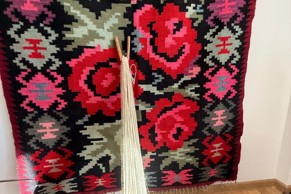 Detaliu de covor țesut cu trandafiri roșii pe fond negru
