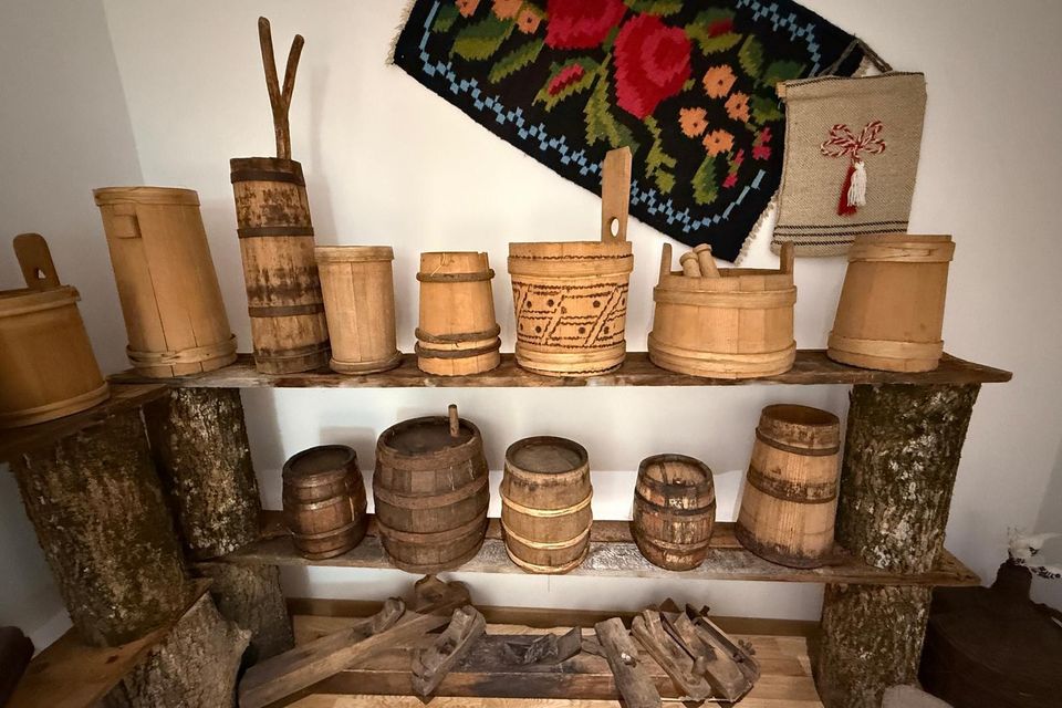 Doniţe, butoiașe și cofe din lemn pe un raft de bârne