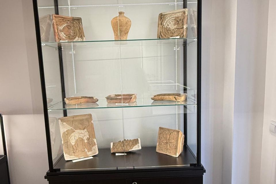 Vitrină neagră cu cahle și vase ceramice, în sala de istorie